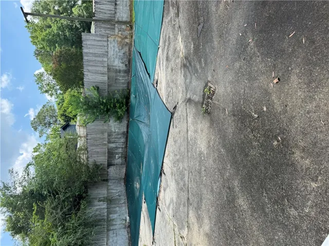 A secured backyard pool and a wooden privacy fence, ready for seasonal enjoyment.