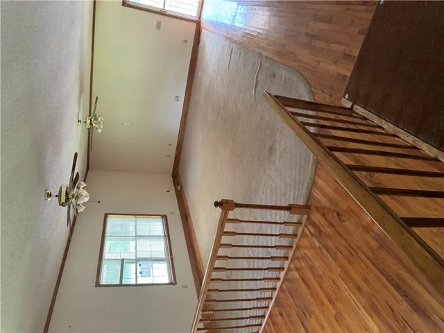 A grand entrance with warm wood flooring and a staircase beckons.