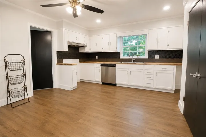A well-appointed kitchen features ample white cabinetry, new counters, new backsplash, and new hardware.