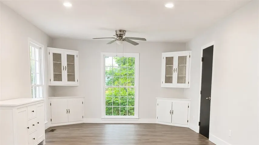 Large well-lit room with generous windows and built-in cabinetry.
