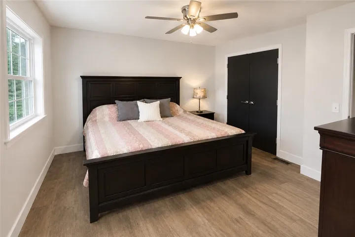 A well-lit bedroom with modern ceramic wood-style flooring.