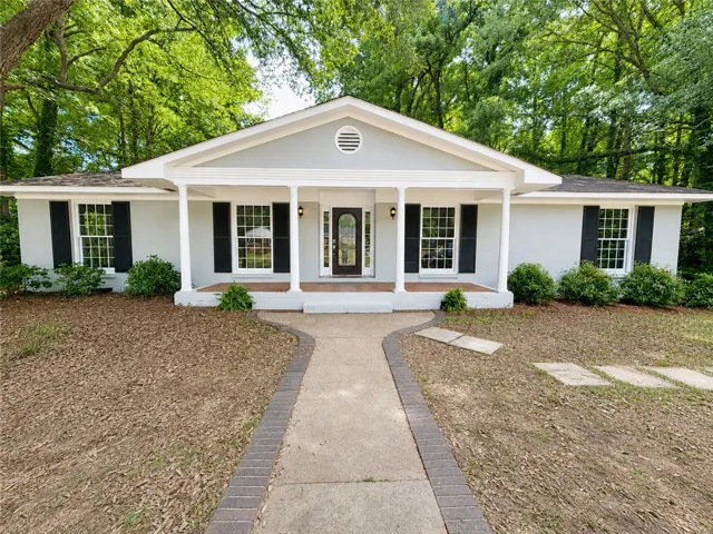 A well-maintained facade with an inviting front porch welcomes you home.