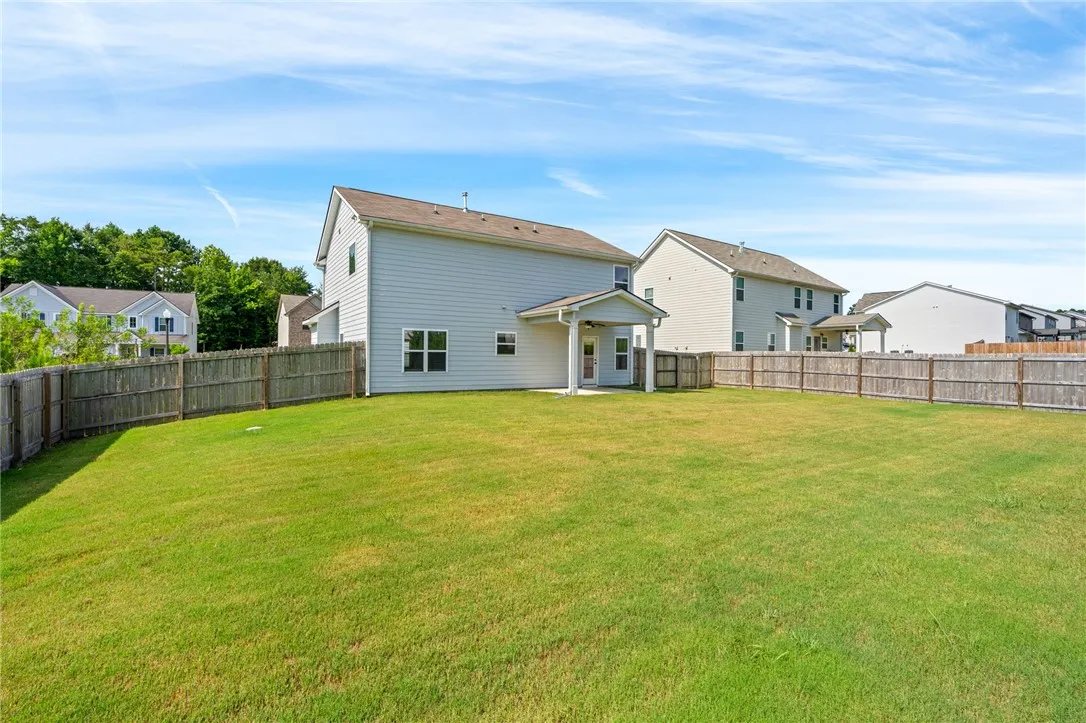 A spacious, fenced backyard offers ample room for outdoor activities and relaxation.