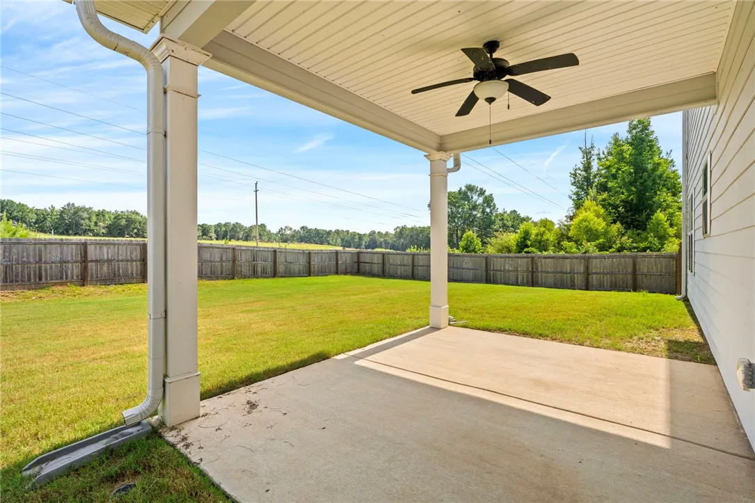 A spacious covered patio provides a delightful outdoor living space overlooking the generous, fenced yard.