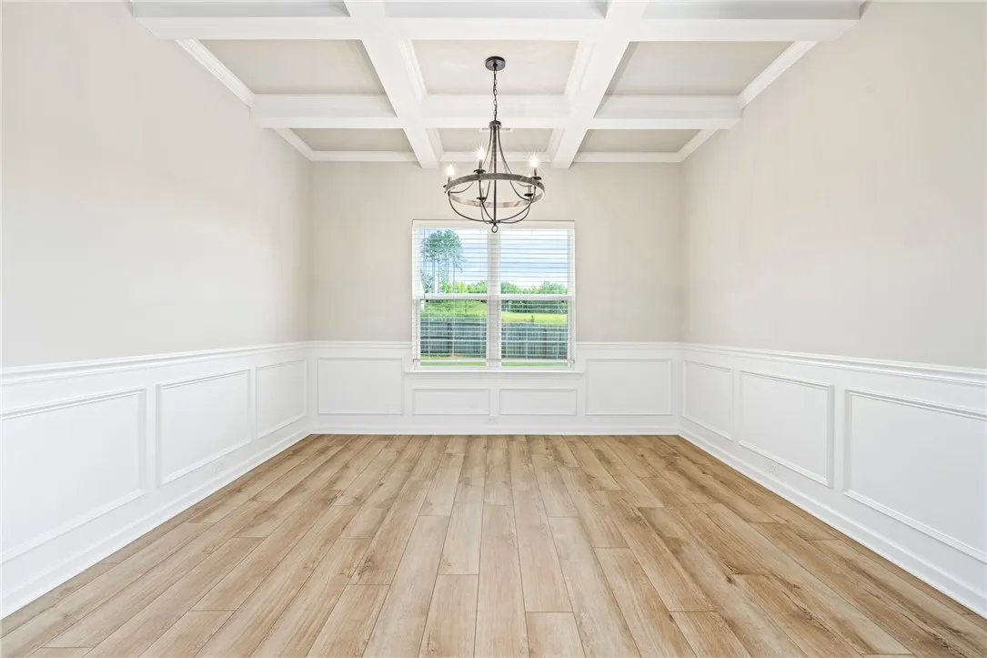 Ornate coffered ceilings and wainscoting define this formal dining space, offering elegant touches throughout.
