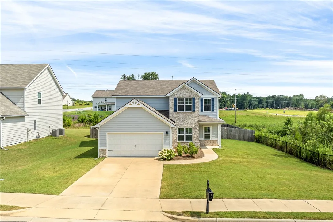 A well-kept lawn complements the inviting facade of this modern residence with a two-car garage.