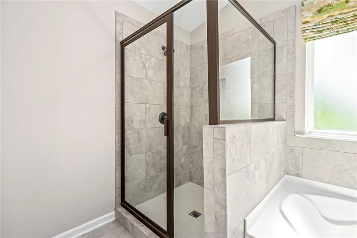 A well-appointed shower enclosure with tile flooring and glass doors creates a refreshing bathroom retreat.