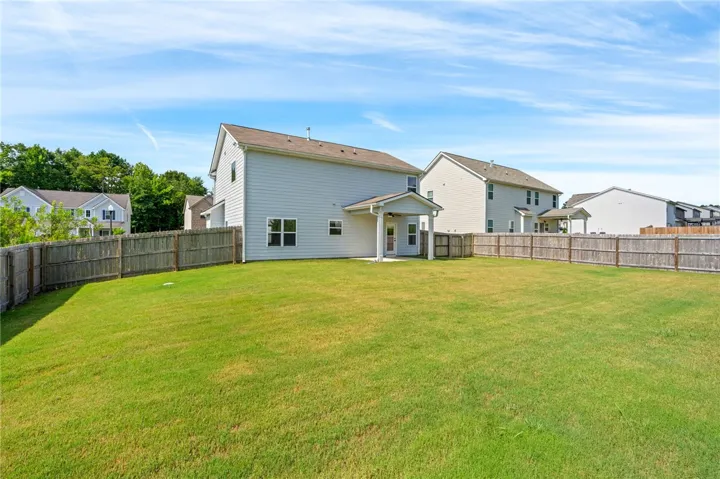 A spacious, fenced backyard offers ample room for outdoor activities and relaxation.