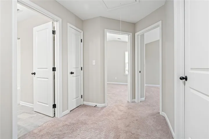 A well-lit landing features soft carpeting, leading to multiple rooms, creating an inviting flow.