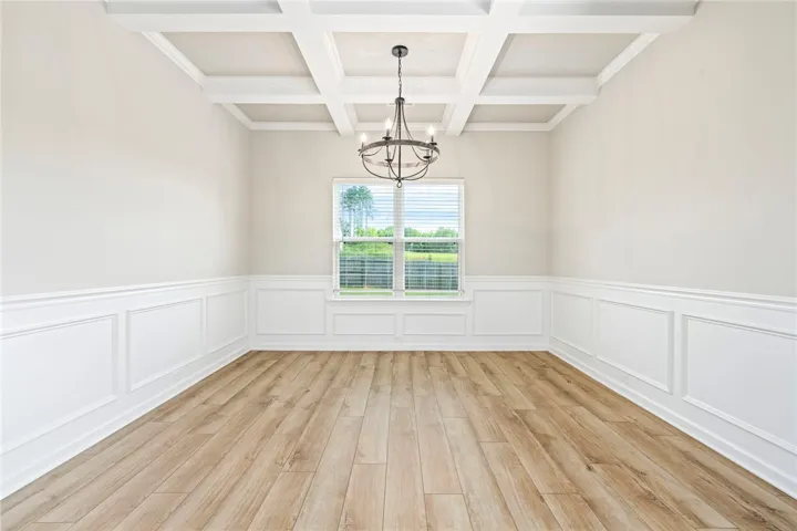 Ornate coffered ceilings and wainscoting define this formal dining space, offering elegant touches throughout.