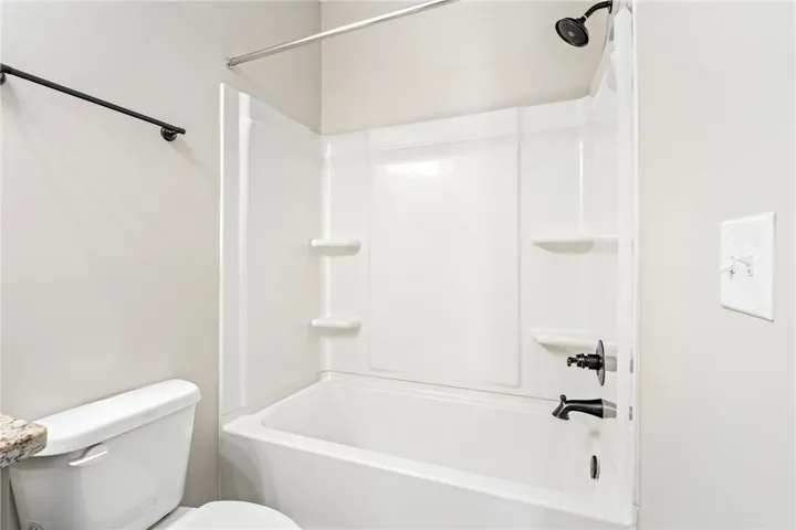 Downstairs Bathroom. A well-appointed bath features a shower/tub combination with ample storage ledges.