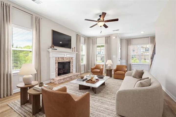 Virtually Staged. A refined gathering space features a brick hearth fireplace and luminous hardwood flooring.