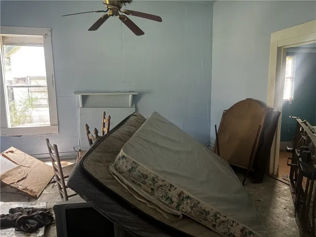 A classic ceiling fan provides airflow in this spacious, light-filled bedroom.