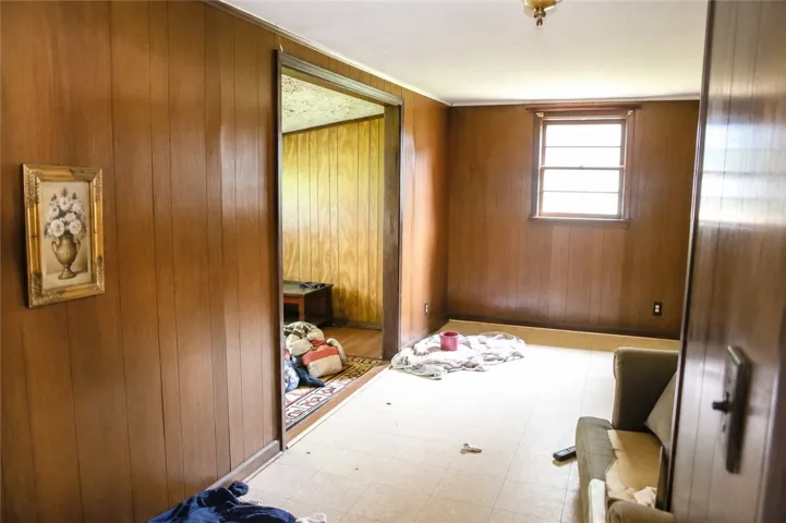 Well-lit room with wood paneling awaits a fresh vision and personal touch.