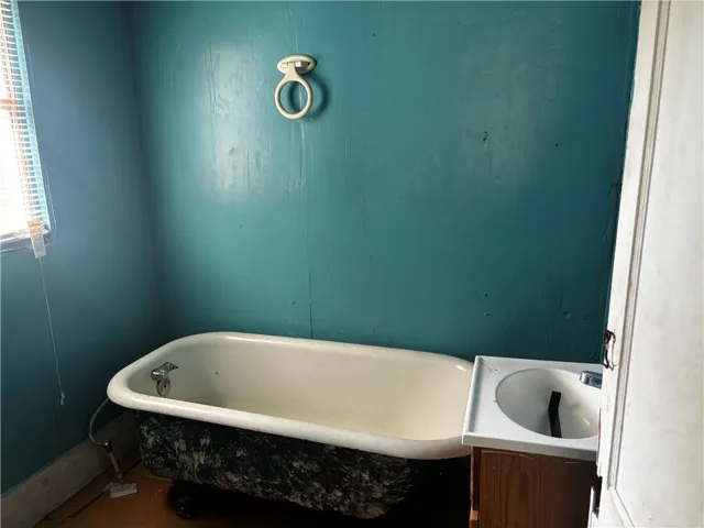 A classic clawfoot tub anchors this bathroom, awaiting a revitalizing touch.