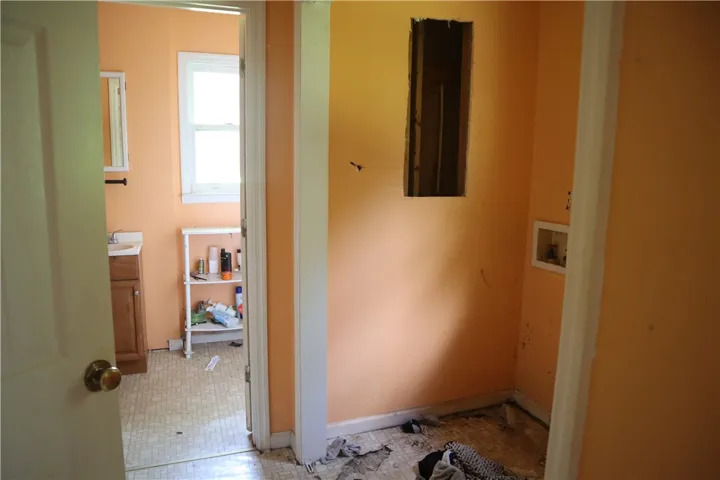 A utilitarian laundry space features a dedicated washer hookup and easy access to a full bathroom.