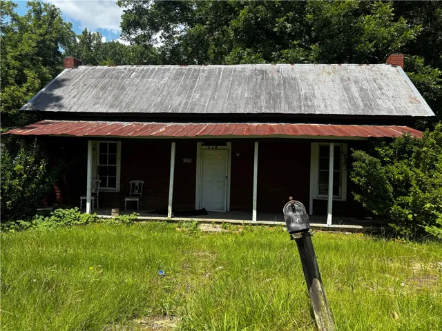 A historic residence with a metal roof and inviting porch awaits your personal touch.