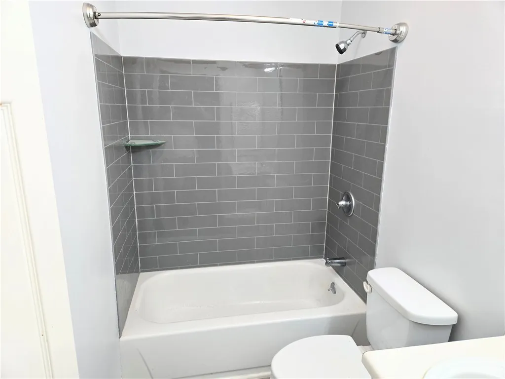 A well-appointed bathroom features a tub and shower combo with contemporary tile surround.