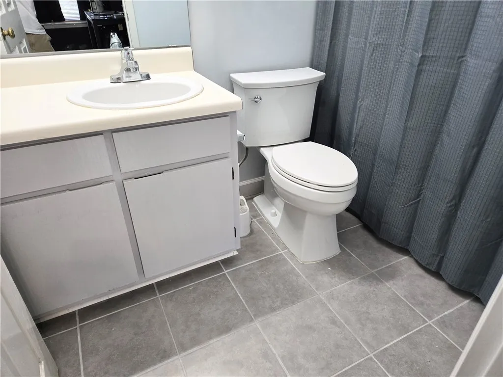 A well-appointed bathroom features a single vanity with ample storage and durable tile flooring.