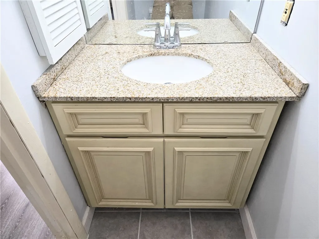 A well-appointed vanity with a granite countertop and integrated sink offers convenient bathroom storage.