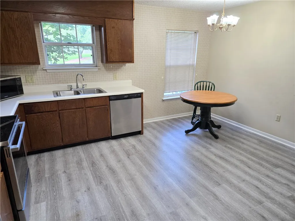 A well-equipped kitchen and dining area features updated flooring and functional appliances.