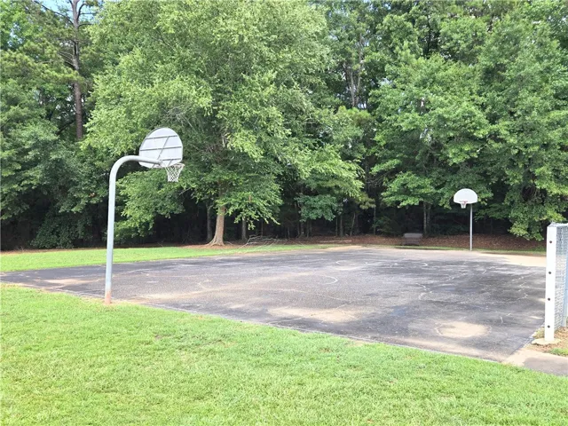 An outdoor basketball court provides recreational opportunities amidst lush greenery.