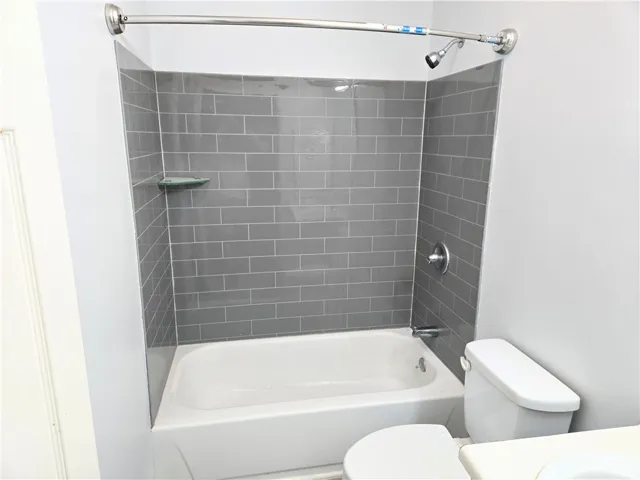A well-appointed bathroom features a tub and shower combo with contemporary tile surround.