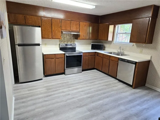 A well-equipped kitchen features wooden cabinetry and modern stainless steel appliances.