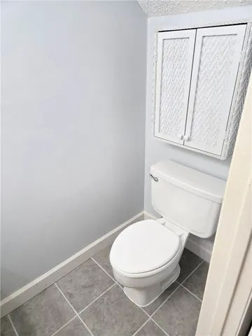 Functional full bathroom featuring practical tiled flooring and integrated storage solutions.