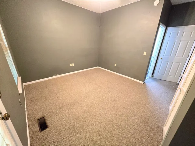 A well-proportioned bedroom with neutral carpet and ample wall space.