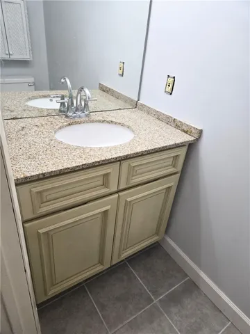 A refined bathroom vanity featuring a granite countertop and ample storage below.
