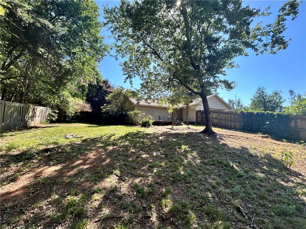 A generous backyard, with a sloped landscape, provides ample space for recreation and outdoor enjoyment.