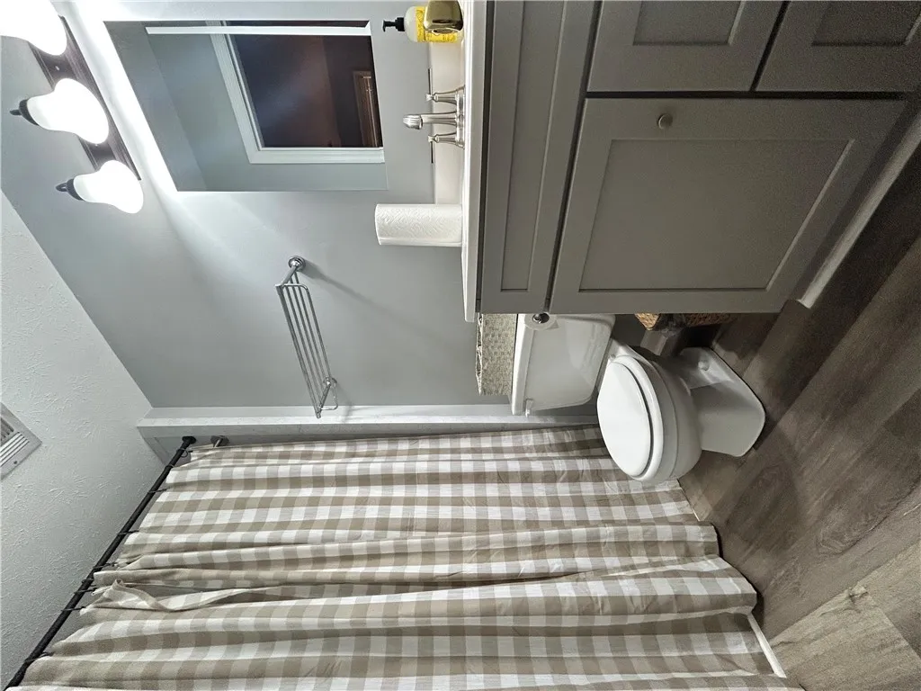A well-appointed bathroom features a practical vanity with ample storage and a charming shower curtain.
