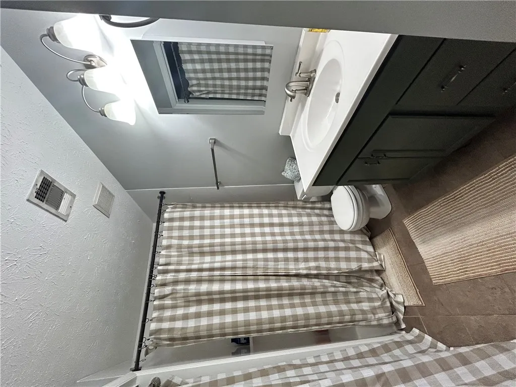 Functional full bathroom featuring a tub/shower combination, vanity with sink, and tile flooring.