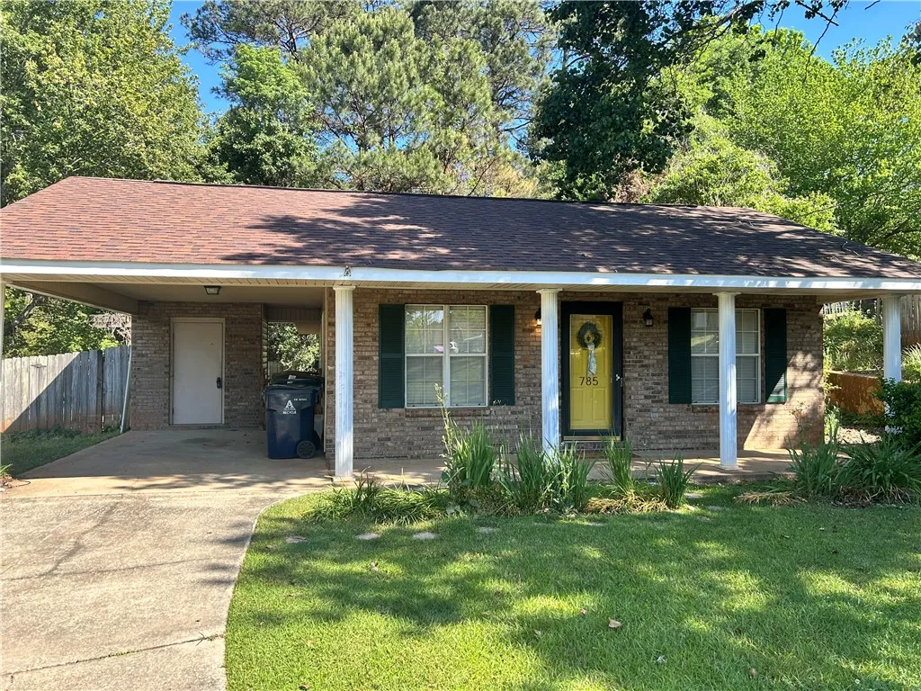 A classic brick exterior offers enduring appeal with a welcoming bright front door and covered entry.