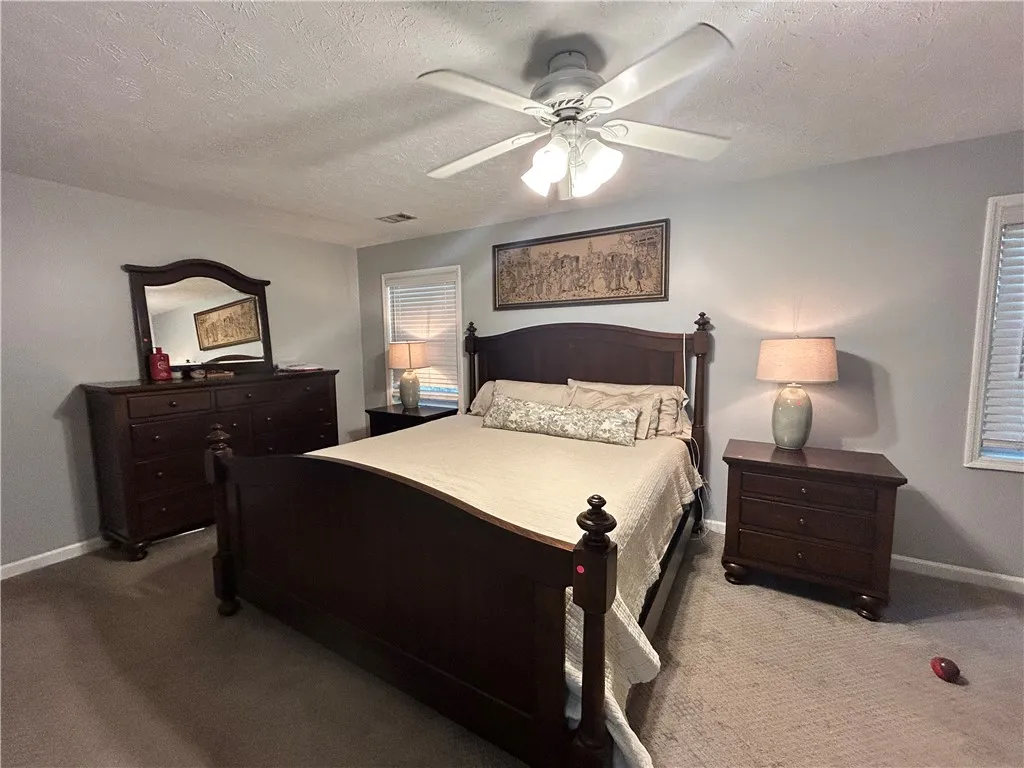A well-appointed bedroom features a prominent ceiling fan for year-round comfort.