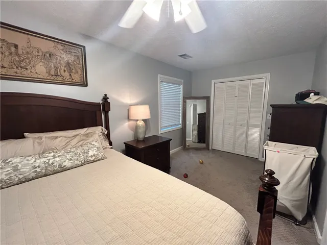 Comfortable bedroom offers a serene retreat with soft carpeting and functional bi-fold closet doors.