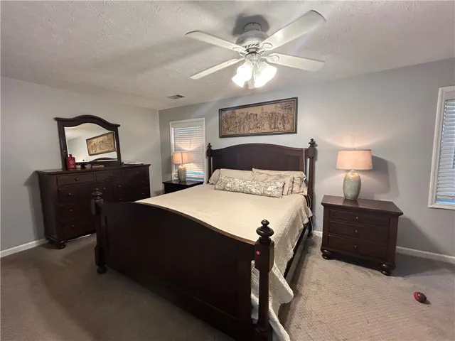 A well-appointed bedroom features a prominent ceiling fan for year-round comfort.