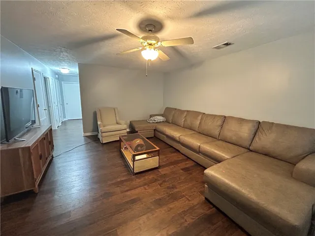 Hardwood floors and a ceiling fan create a comfortable atmosphere in this inviting living space.