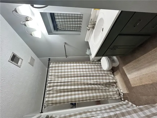 Functional full bathroom featuring a tub/shower combination, vanity with sink, and tile flooring.