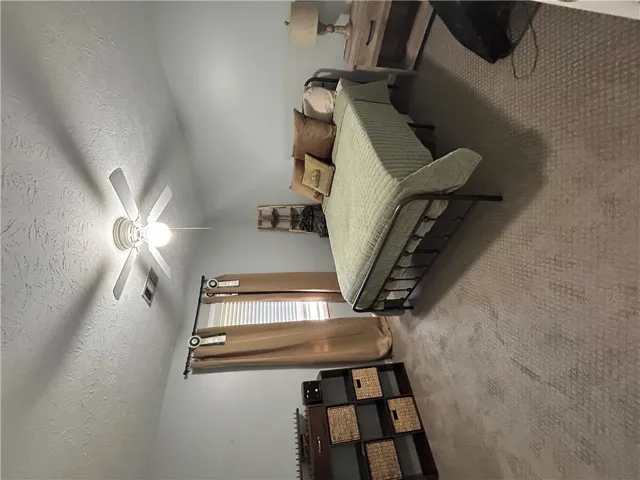Relax in this comfortable bedroom featuring soft carpeting and natural light.