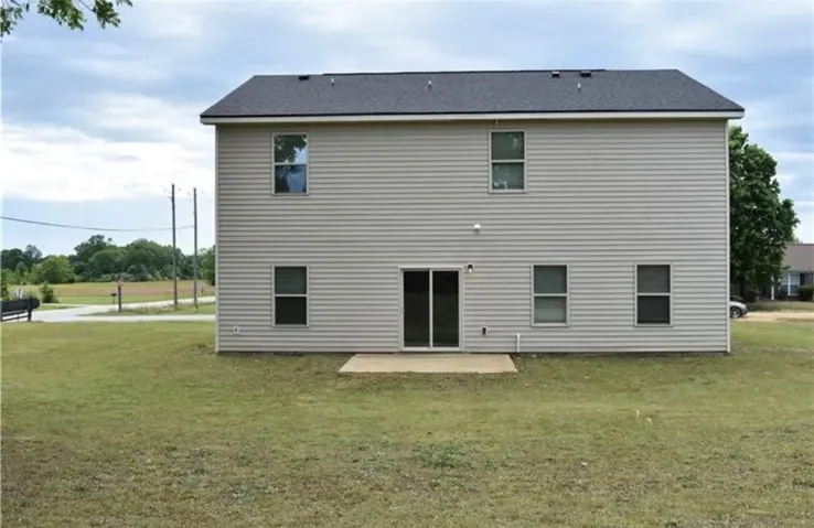 A classic two-story residence with a clean backyard, offering a blank canvas for outdoor living.