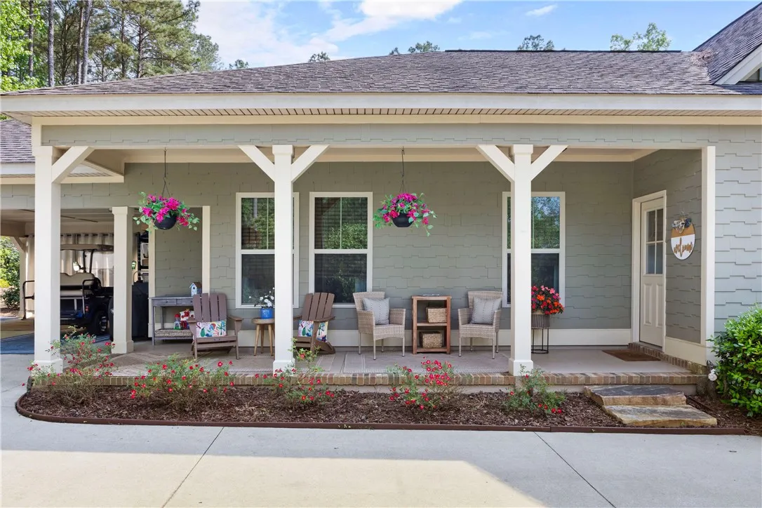 A welcoming front porch, shaded by a broad roof, creates an inviting entryway.