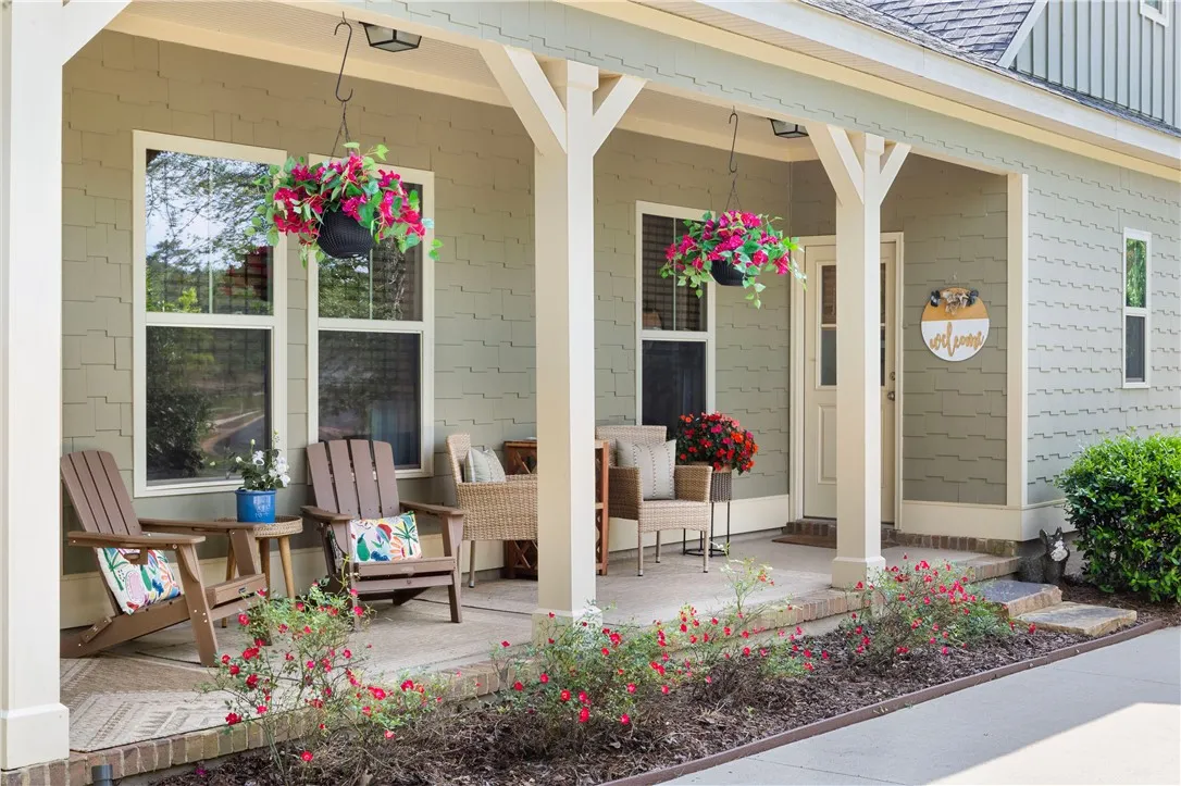 A welcoming covered porch with a cozy seating area awaits, perfect for enjoying quiet moments outdoors.