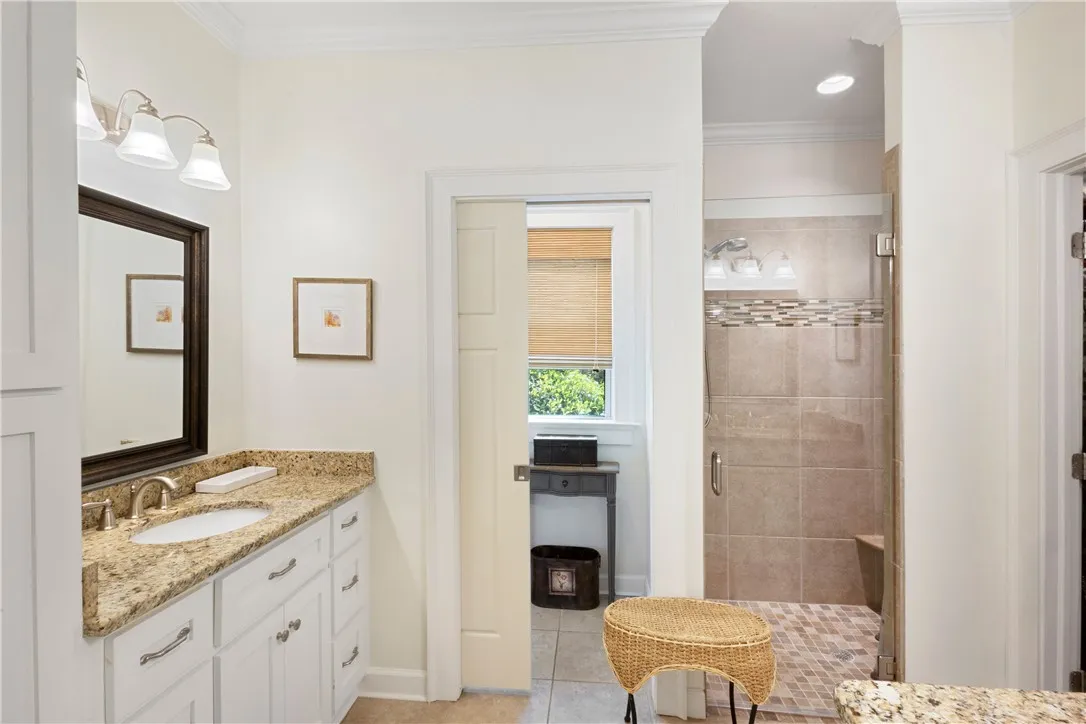 Granite counters and pristine white cabinetry define this well-appointed bathroom space.