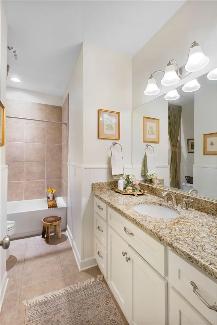 Granite counters and tile flooring enhance this well-appointed bathroom.