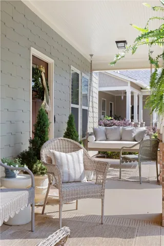 A welcoming front porch beckons with a comfortable swing and charming wicker seating, perfect for quiet mornings.