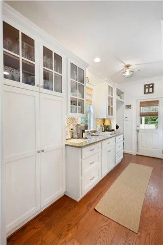 Granite counters and rich hardwood floors create a welcoming atmosphere in this thoughtfully designed kitchen.