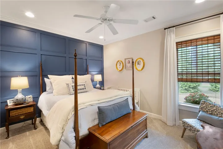 A well-appointed sleeping area features wall paneling and a large window overlooking lush greenery.