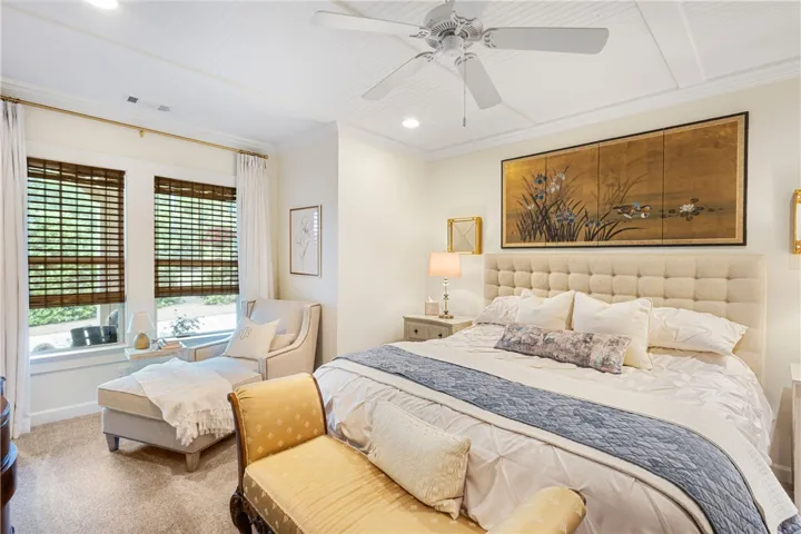 Relax in this tranquil bedroom, featuring a classic tufted headboard and a cozy window-side chaise lounge.